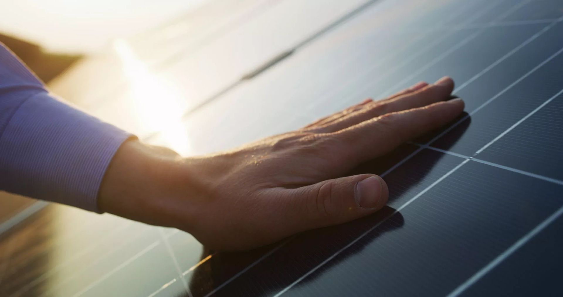 Eine Hand auf einem Solarpaneel
